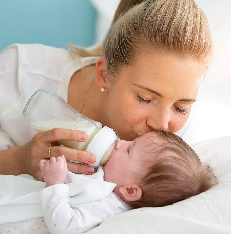 mother-feeding-daughter-bed